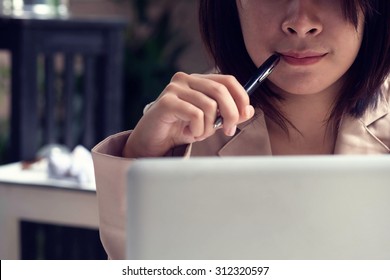 business girl thinking pointing pen on her mouse vintage tone
