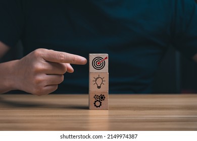 Business goals and marketing strategies. Businessman selecting target icon on wooden lock. economic analysis, Company strategy development, success. business background - Shutterstock ID 2149974387