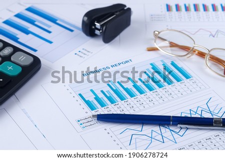 business graph, sales report, calculator, pen and eyeglasses
