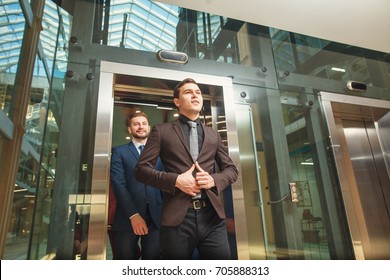 business group comes out from glass Elevator