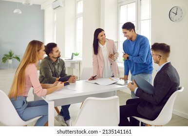 Business Group In Office. Successful Marketing Team Working Together On New Startup Project In Modern Bright Office. Smiling Young People Discuss Work At Table. Collaboration Concept.