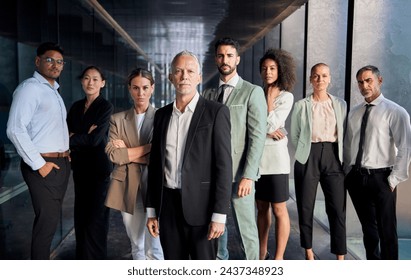 Business group portrait posing with confidence attitude. Successful diverse team looking at camera leading boss in front. Professional people workers in suits standing in office building corridor - Powered by Shutterstock