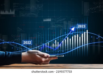 Business growth in 2023. New opportunities and success. Economic and financial growth. The person is holding smartphone with hologram - Shutterstock ID 2195577733