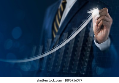 Business growth, boost up business, progress in business or success concept. Businessman is drawing exponential growth graph on dark tone background.