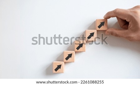Business growth concept, male hands arranged stacked wooden blocks steps on white table, future business growth arrow, development to achieve goals, copy space.