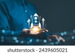 Business growth concept. Professional businessman projecting a holographic rocket symbolizing startup success and growth acceleration. Rising earnings, increasing financial profits, Wealth fast,