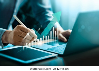 Business growth and financial success concept with rising graph and futuristic analytics. Businessman using digital pen and tablet for data-driven strategy, smart investment, and performance planning.