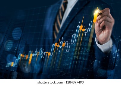 Business Growth, Progress Or Success Concept. Businessman Is Drawing A Growing Virtual Hologram Stock Bar Chart On Dark Blue Background.