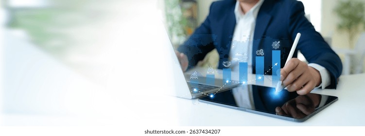 Business growth strategy concept. A professional uses a digital tablet to interact with blue bar graphs and business strategies icons; teamwork, innovation, business collaboration, sustainability.