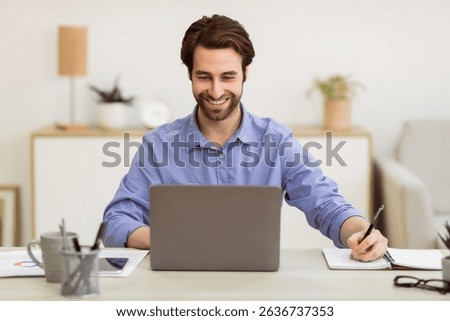 Business Guy Working Taking Notes Sitting At Laptop In Office