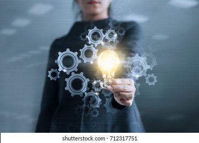 Business hand holding light bulb and gear web engineering to success on metal texture background, technology and innovation concept - Powered by Shutterstock