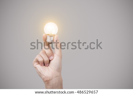 Business hand holding light bulb, concept of new ideas and innovation, creativity.