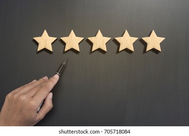 Business hand select five star rating on wooden. concept customer service excellent