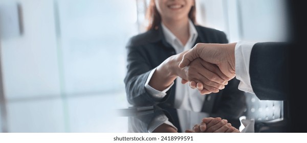 Business handshake. Asian business people making a handshake, close up. Two corporate businessman shaking hands during meeting in office, business union company, successful deal, teamwork, partnership - Powered by Shutterstock
