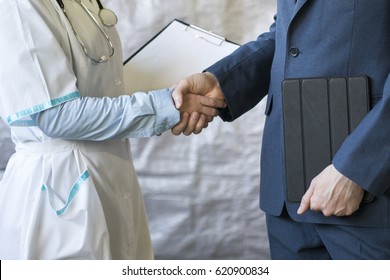 Business Handshake. Businessman Shaking Hands With Doctor