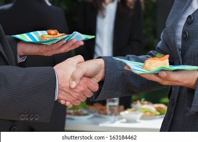 Business handshake during lunch on the open air