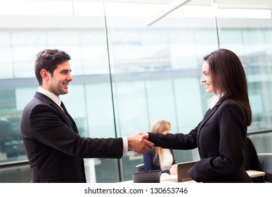 Business Handshake At Modern Office With Bussiness People On Background