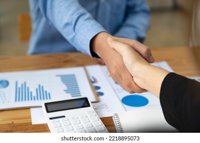 Business Handshake In The Office Meeting, Financing Accounting Concept. Businessman Investment Consultant Analyzing Company Financial Report Balance Sheet Statement Working With Digital Graphs.	

