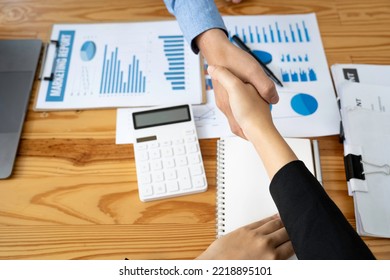 Business Handshake In The Office Meeting, Financing Accounting Concept. Businessman Investment Consultant Analyzing Company Financial Report Balance Sheet Statement Working With Digital Graphs.	

