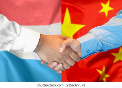 Business Handshake On Background Of Two Flags. Men Handshake On Background Of Luxembourg And China Flag. Support Concept