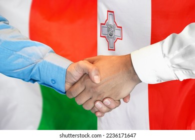Business handshake on background of two flags. Men handshake on background of Madagascar flag and flag of Malta. Support concept - Shutterstock ID 2236171647