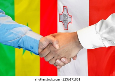 Business handshake on background of two flags. Men handshake on background of Senegal flag and flag of Malta. Support concept - Shutterstock ID 2236171851