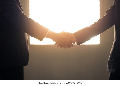 Business Handshake And Business People With Silhouette