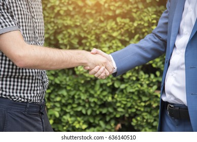 Business handshake. Two businessmen reaching an agreement and making a deal