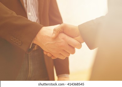 Business Handshake Of Two Men Demonstrating Their Agreement To Sign Agreement Or Contract Between Their Firms / Companies / Enterprises.