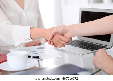 Business handshake. Two women are shaking hands after meeting or  negotiation. 