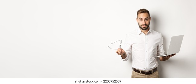 Business. Handsome businessman looking confused after working with laptop, standing against white background