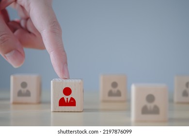 Business Hiring And Recruitment Selection. Career Opportunity. Human Resource Management. Hand Choosing Red Businessman Icon On Wooden Block. Choice Of Employee Leader From The Crowd.