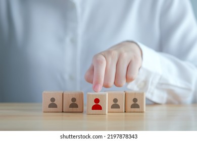 Business Hiring And Recruitment Selection. Career Opportunity. Human Resource Management. Hand Choosing Red Human Icon On Wooden Block. Choice Of Employee Leader Or New Employee From The Crowd.