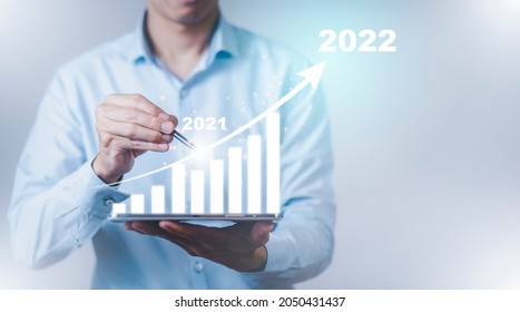 Business hold pen touch growth data chart arrow with diagram 2022 budget, Businessman pointing arrow graph corporate future growth year 2021 to 2022, Development to success and motivation.