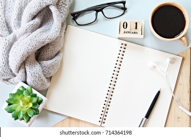 Business, holiday or new year planning concept : Desk table with scarf, notebook paper, accessories, cube calendar and coffee cup, Top view or flat lay with copy space ready for adding or mock up