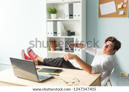 Business, humor and people concept - Handsome funny man in white shirt has a rest sitting at the table