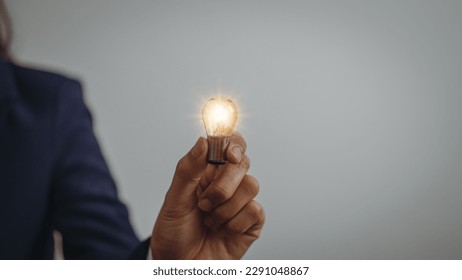 Business idea concept, Hands of business woman in suit holding light bulb with innovation and inspiration creative agency new beginning Analyzing data