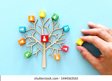 Imagen de negocio de árbol de madera con iconos de personas sobre mesa azul, recursos humanos y concepto de gestión