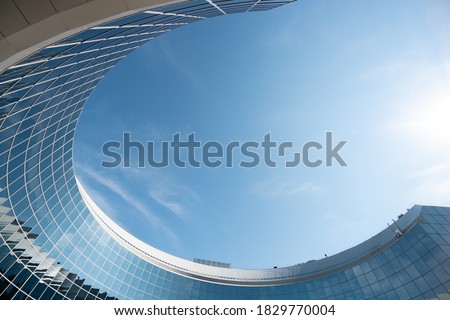 
business industrai city with mirror windows with reflections of blue sky with clouds lovely abstract modern circular building