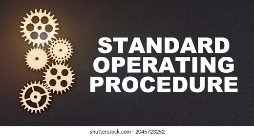 Business and industry concept. On a black background, gears and the inscription - Standard Operating Procedure