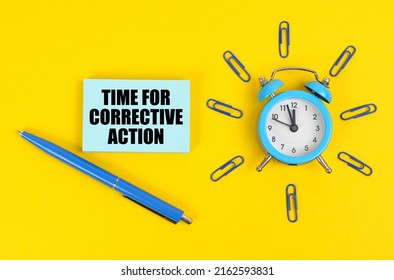 Business and industry concept. On the yellow surface there is an alarm clock, a pen and stickers with the inscription - Time for Corrective Action