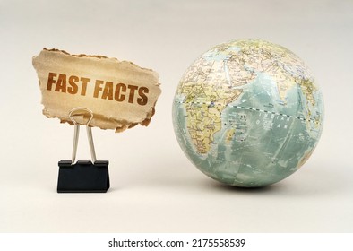 Business And Industry Concept.Near The Globe There Is A Clip With A Cardboard Plate On Which It Is Written - Fast Facts