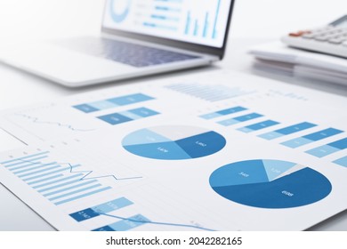 Business intelligence and analysis reports. Many graphs on reports and laptop display.  - Shutterstock ID 2042282165