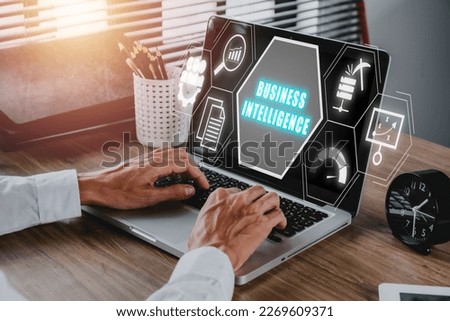 Business intelligence concept, Businees person working on laptop computer with business intelligence icon on virtual screen, data mining, analysis, measurement, benchmarking, report and management. 