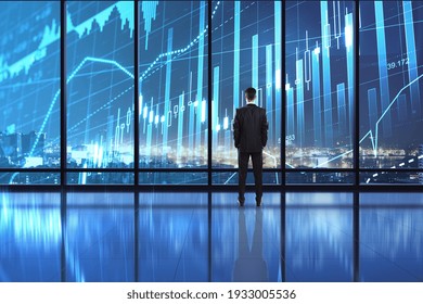 Business investment concept with digital screen on window with stock market chart and businessman looking at night city. Double exposure - Powered by Shutterstock