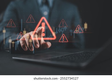 Business investment risks. Businessman use laptop with virtual stock growth graph with red warning sign for caution in investing economic situation warning, investment in economy crisis.