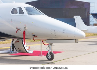 Business Jet With Open Door And Red Carpet, View Of The Nose And Cockpit Of The Airplane