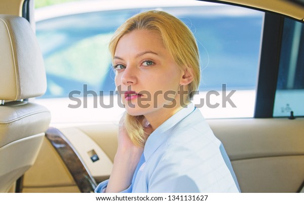 Business lady passenger luxury car salon.\
Personal assistant and driver. Business life concept. Business\
woman sit on backseat. Busy lady passenger leather car salon enjoy\
journey with\
chauffeur.