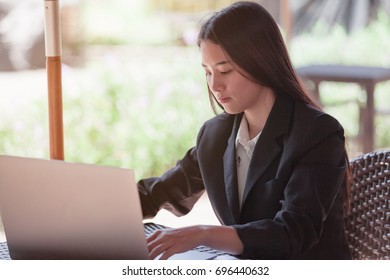 Business lady pondering over ideas for her task while sitting with laptop in modern cafe