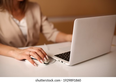 Business Lady Woman In Beige Formal Suit Works At The Computer. Hand And Computer Mouse Close-up On A Blurred Image Of A Woman.